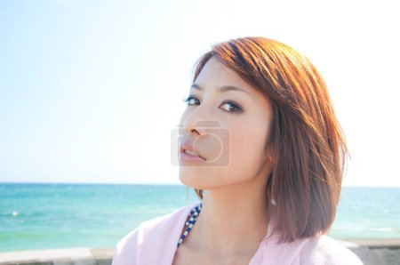 Téléchargez les photos : Jeune femme asiatique posant sur la plage - en image libre de droit