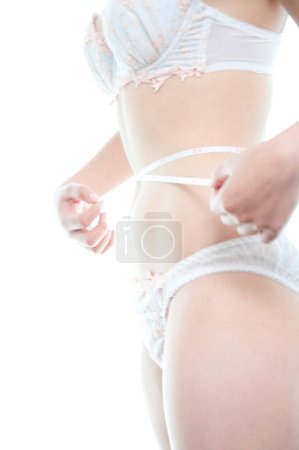 Photo for Woman in white lingerie measuring waist - Royalty Free Image