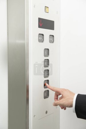 Foto de Mano masculina pulsando el botón ascensor - Imagen libre de derechos