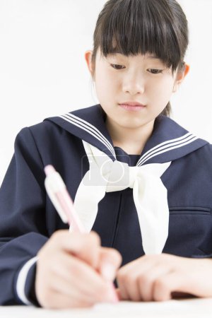Téléchargez les photos : Souriant Japonais étudiant en uniforme scolaire étudiant à l'école - en image libre de droit