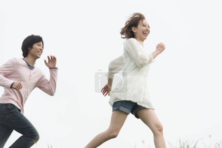 Photo for Couple running through the field - Royalty Free Image