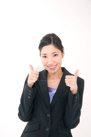 Photo for Young businesswoman with thumbs up, studio shot - Royalty Free Image