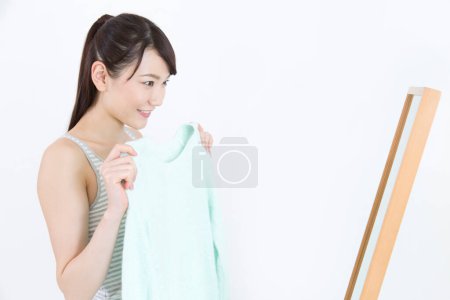 Téléchargez les photos : Portrait de jeune femme choisissant des vêtements - en image libre de droit
