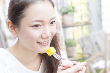 Foto de Joven asiático mujer comer en casa - Imagen libre de derechos