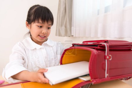 Photo for Little asian girl doing homework - Royalty Free Image