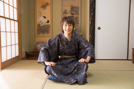retrato de joven japonés guapo en yukata tradicional en hotel termal étnico