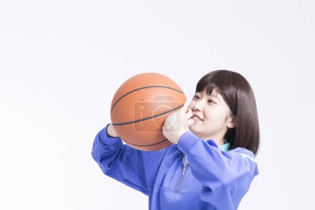 Téléchargez les photos : Portrait studio de jeune fille asiatique en vêtements de sport avec ballon de basket - en image libre de droit