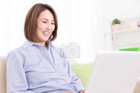Photo for Young woman using laptop at home - Royalty Free Image