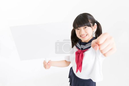 Photo for Portrait of beautiful young student in school uniform holding white blank board - Royalty Free Image