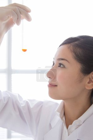 Photo for Asian female scientist in laboratory with tube - Royalty Free Image