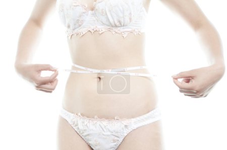 Foto de Mujer en lencería blanca que mide la cintura - Imagen libre de derechos