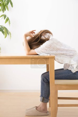 Téléchargez les photos : Jeune femme triste stressée à la table à la maison - en image libre de droit