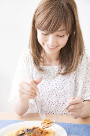 Téléchargez les photos : Belle femme japonaise avec spaghetti à la maison - en image libre de droit