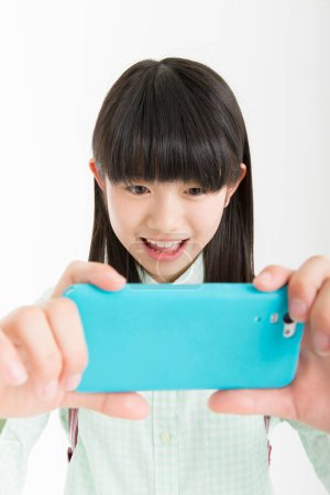 Téléchargez les photos : Sourire fille japonaise en utilisant smartphone - en image libre de droit
