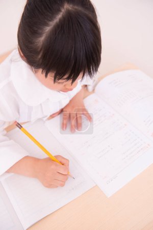 Photo for Little asian girl doing homework - Royalty Free Image