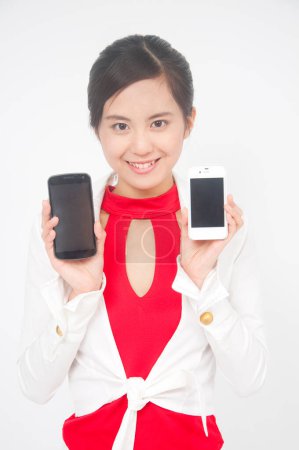 Foto de Primer plano asiático mujer celebración de dos teléfonos - Imagen libre de derechos