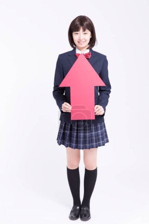 Téléchargez les photos : Portrait studio d "écolière japonaise souriante avec flèche rouge - en image libre de droit
