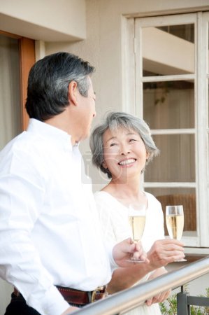 Téléchargez les photos : Senior asiatique couple boire champagne à la maison - en image libre de droit