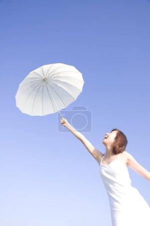 Foto de Hermosa mujer asiática posando en la playa con paraguas - Imagen libre de derechos