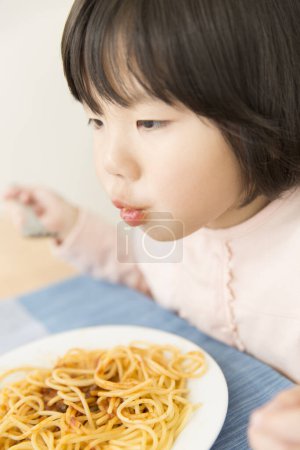 Photo for Asian little girl eating spaghetti - Royalty Free Image