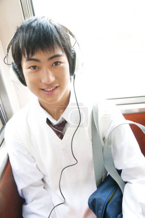 Foto de Asiático joven estudiante escuchar música en autobús - Imagen libre de derechos