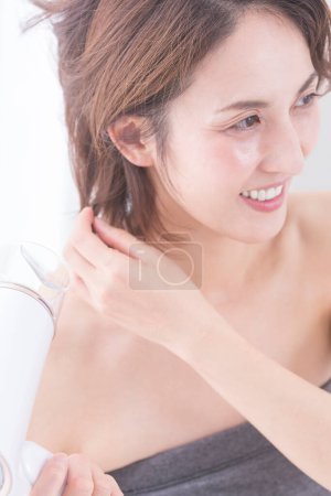 Foto de Retrato de hermosa mujer japonesa madura secándose el pelo - Imagen libre de derechos