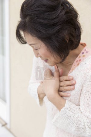 Foto de Asiático maduro mujer teniendo dolor en pecho - Imagen libre de derechos