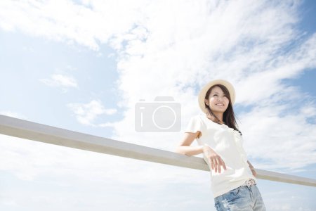 Téléchargez les photos : Portrait de femme asiatique sur fond bleu ciel - en image libre de droit