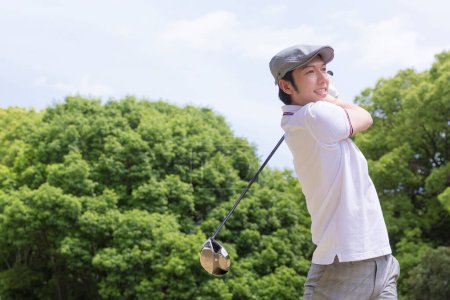 Téléchargez les photos : Asiatique l'homme dans un blanc chemise et gris pantalon jouer golf - en image libre de droit