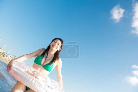 Foto de Joven asiático mujer posando en la orilla del mar con inflable anillo - Imagen libre de derechos