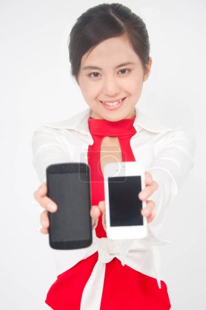 Téléchargez les photos : Fermer asiatique femme tenant deux téléphones - en image libre de droit