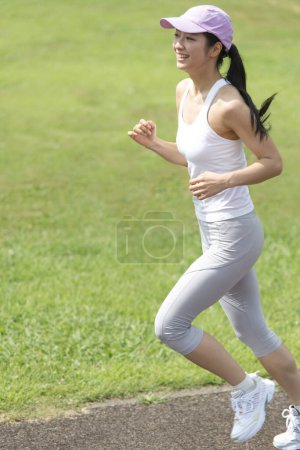 Foto de Deportiva japonesa mujer corriendo en el parque de verano - Imagen libre de derechos