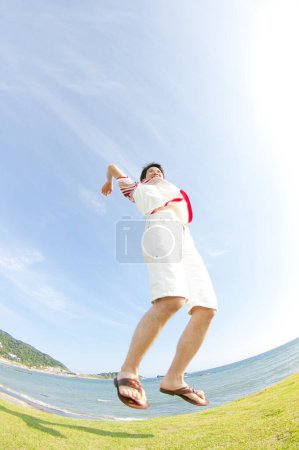 Photo for Asian man jumping on a beach - Royalty Free Image