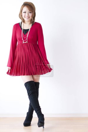 Foto de Hermosa joven asiática mujer en rojo vestido y botas - Imagen libre de derechos