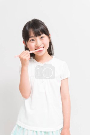 asian girl holding a toothbrush