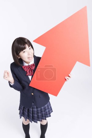 Photo for Studio portrait of smiling Japanese schoolgirl with red arrow - Royalty Free Image