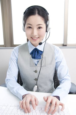 Foto de Asiático servicio al cliente mujer agente con auriculares - Imagen libre de derechos