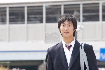Téléchargez les photos : Portrait d'un étudiant japonais marchant en ville - en image libre de droit