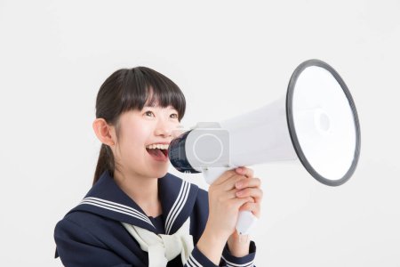 Téléchargez les photos : Jeune asiatique écolière avec mégaphone sur fond blanc - en image libre de droit