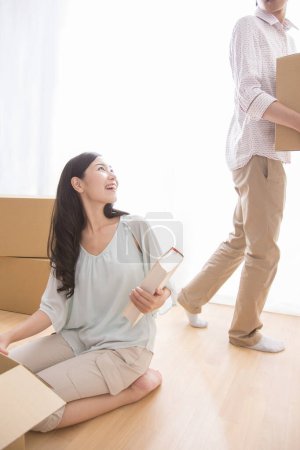 Téléchargez les photos : Jeune homme et femme asiatique avec des boîtes en carton déménageant dans un nouvel appartement - en image libre de droit
