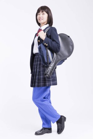 Téléchargez les photos : Portrait de belle jeune écolière japonaise en uniforme isolé sur blanc - en image libre de droit