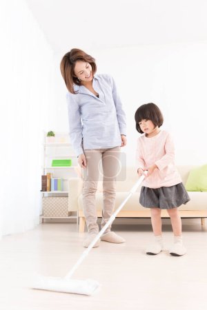 Téléchargez les photos : Asiatique mère et petite fille nettoyage maison ensemble - en image libre de droit