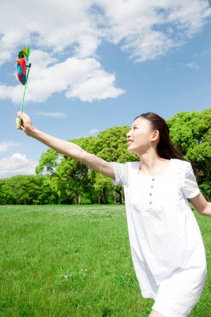 Foto de Hermosa chica con un molino de viento juguete al aire libre - Imagen libre de derechos