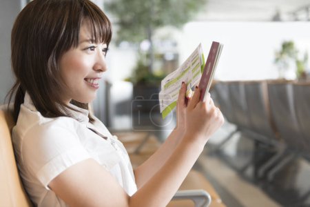 Téléchargez les photos : Jeune femme avec tablette numérique à l'aéroport - en image libre de droit