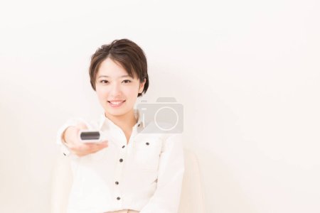 Téléchargez les photos : Jeune belle asiatique femme avec télécommande - en image libre de droit