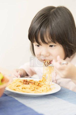 Photo for Asian little girl eating spaghetti - Royalty Free Image