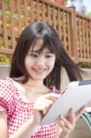 Photo for Beautiful Japanese young woman using tablet. close up view - Royalty Free Image