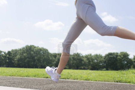 Téléchargez les photos : Femme japonaise sportive faisant du jogging dans un parc d'été - en image libre de droit