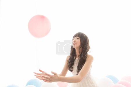 Photo for Happy asian woman sitting on the floor with balloons - Royalty Free Image