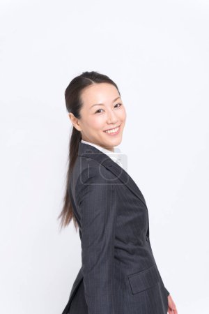 Téléchargez les photos : Jeune femme en costume d'affaires souriant sur fond blanc - en image libre de droit